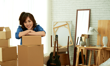 young-attractive-woman-leaning-pile-package-boxes-smiling 1